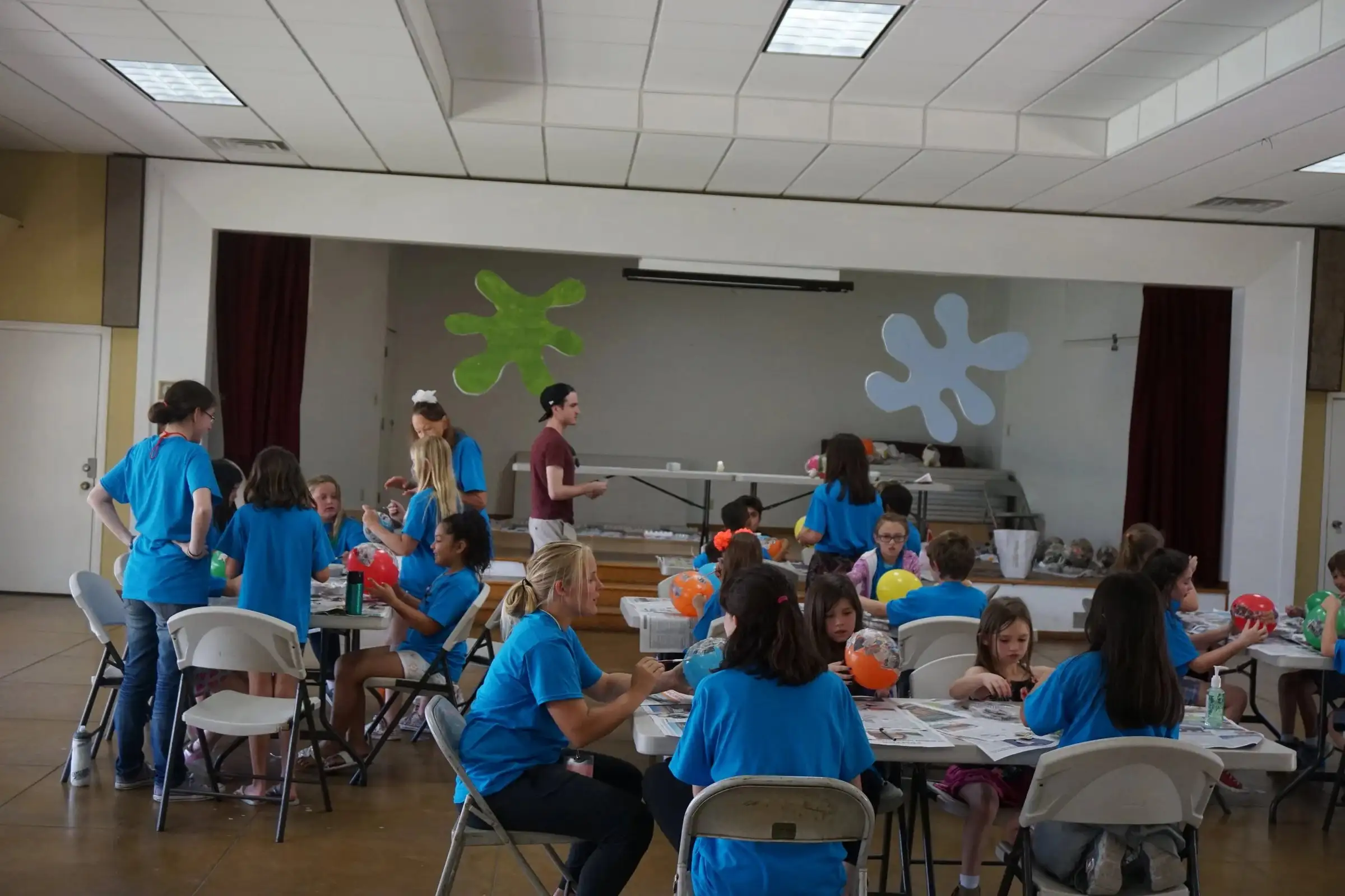 Kids and leaders gathered around tables in the fellowship hall